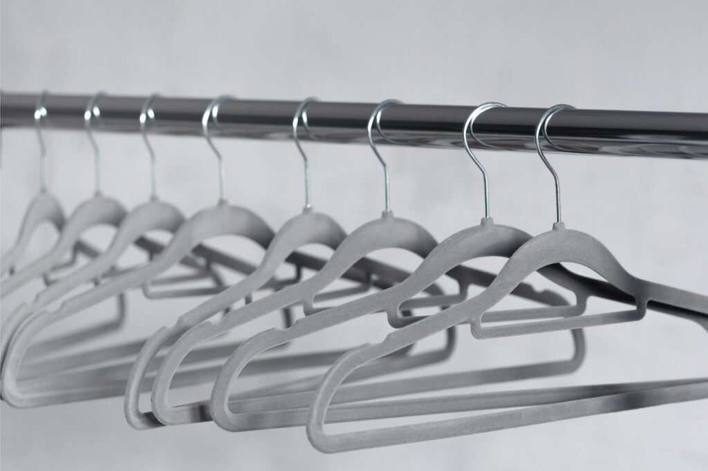 Modern grey empty hangers on neutral background.