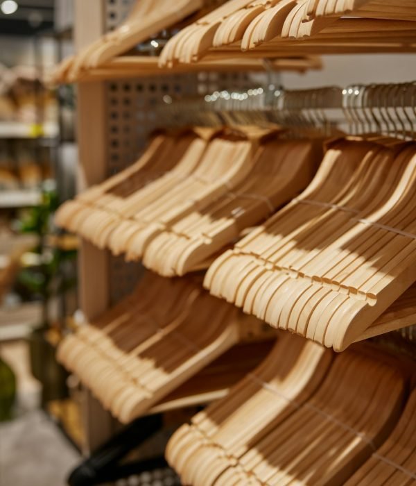 Many empty wooden hangers for clothes on shop store rack